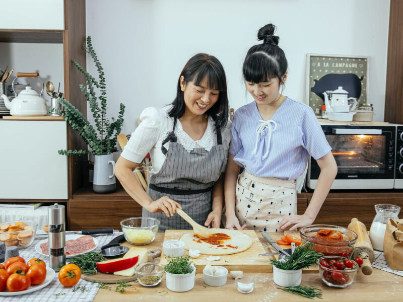 Two women making authentic Italian pizza.